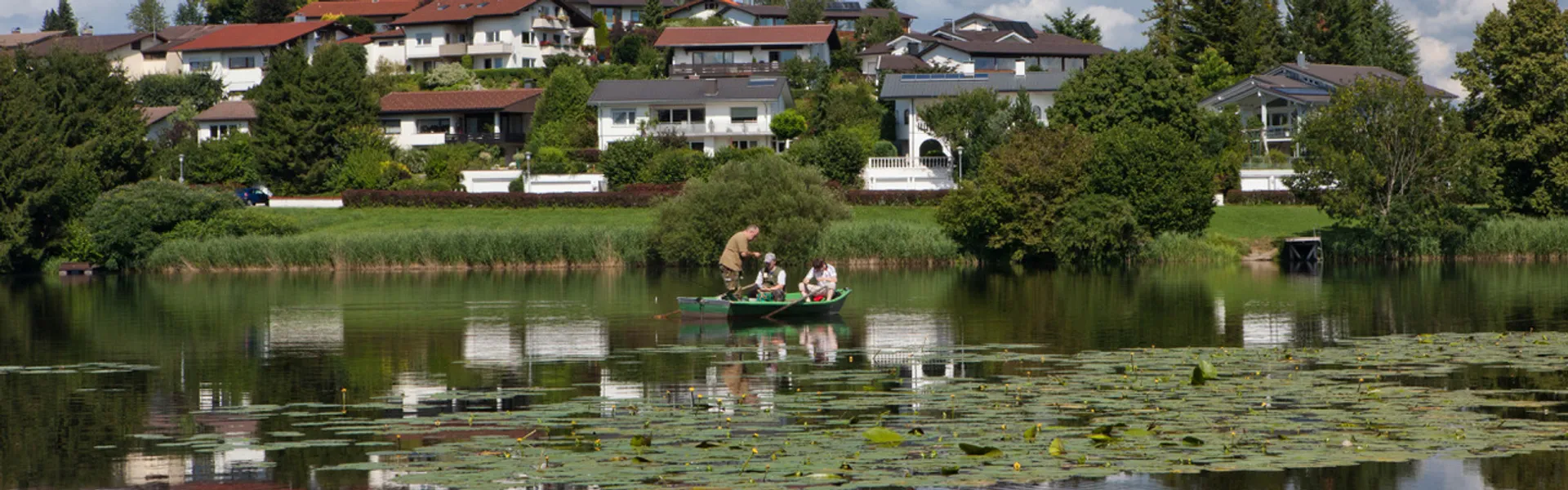 Vereinsmitglieder beim Angeln vom Boot aus, auf dem Neuravensburger Weiher